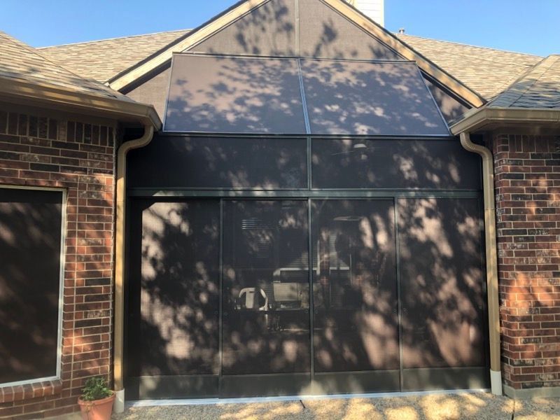 A brick house with a screened in garage door