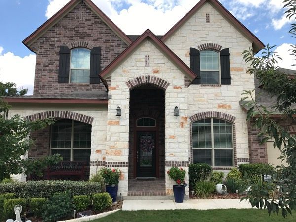 A large brick house with black shutters on the windows