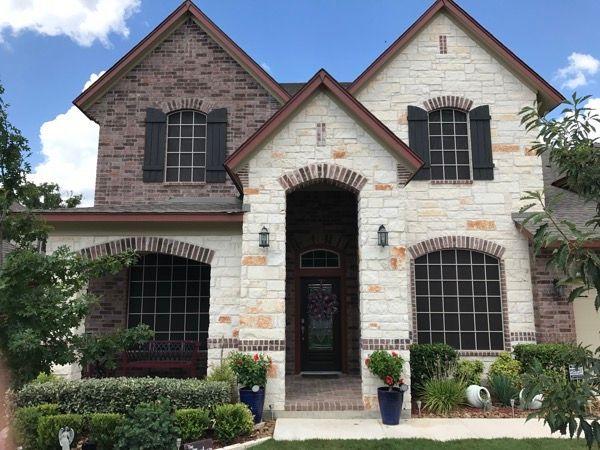 A large brick house with black shutters on the windows