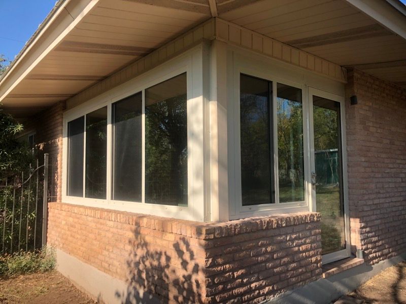 A brick house with a lot of windows and a sliding glass door.