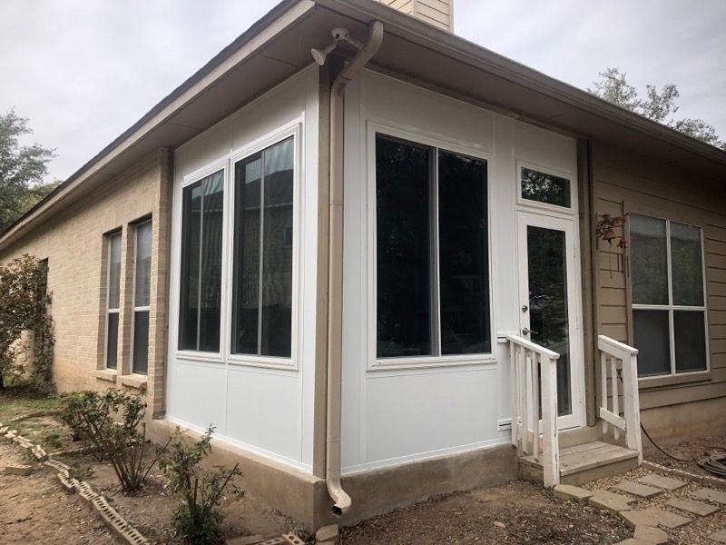 A house with a screened in porch and a lot of windows.