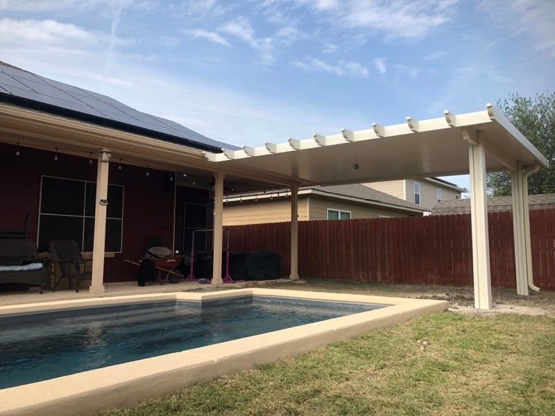 A house with a pool and a pergola in the backyard.
