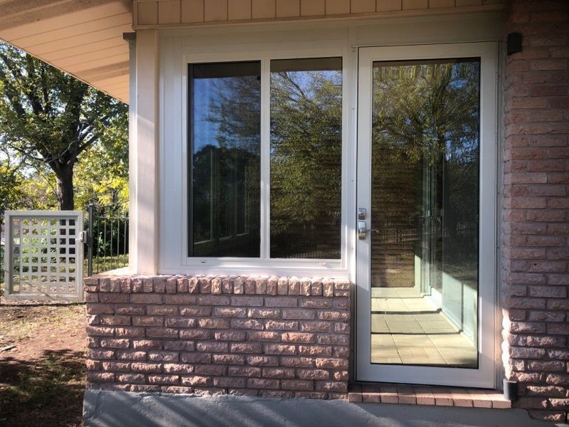 A brick house with a white door and two windows