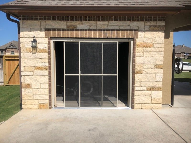 A brick building with a screened in garage door