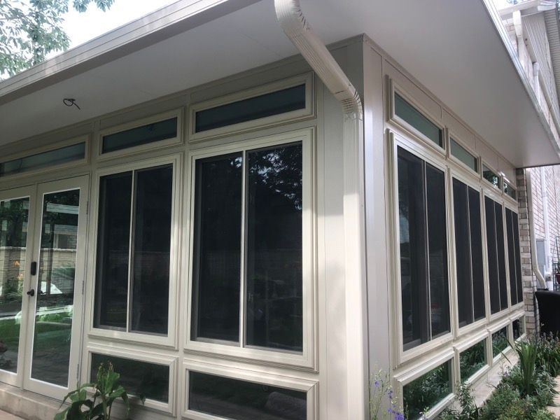 A house with a lot of windows and a screened in porch.