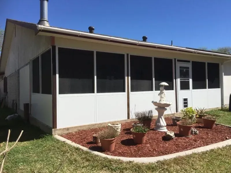 A white house with blue stripes on the side is under construction