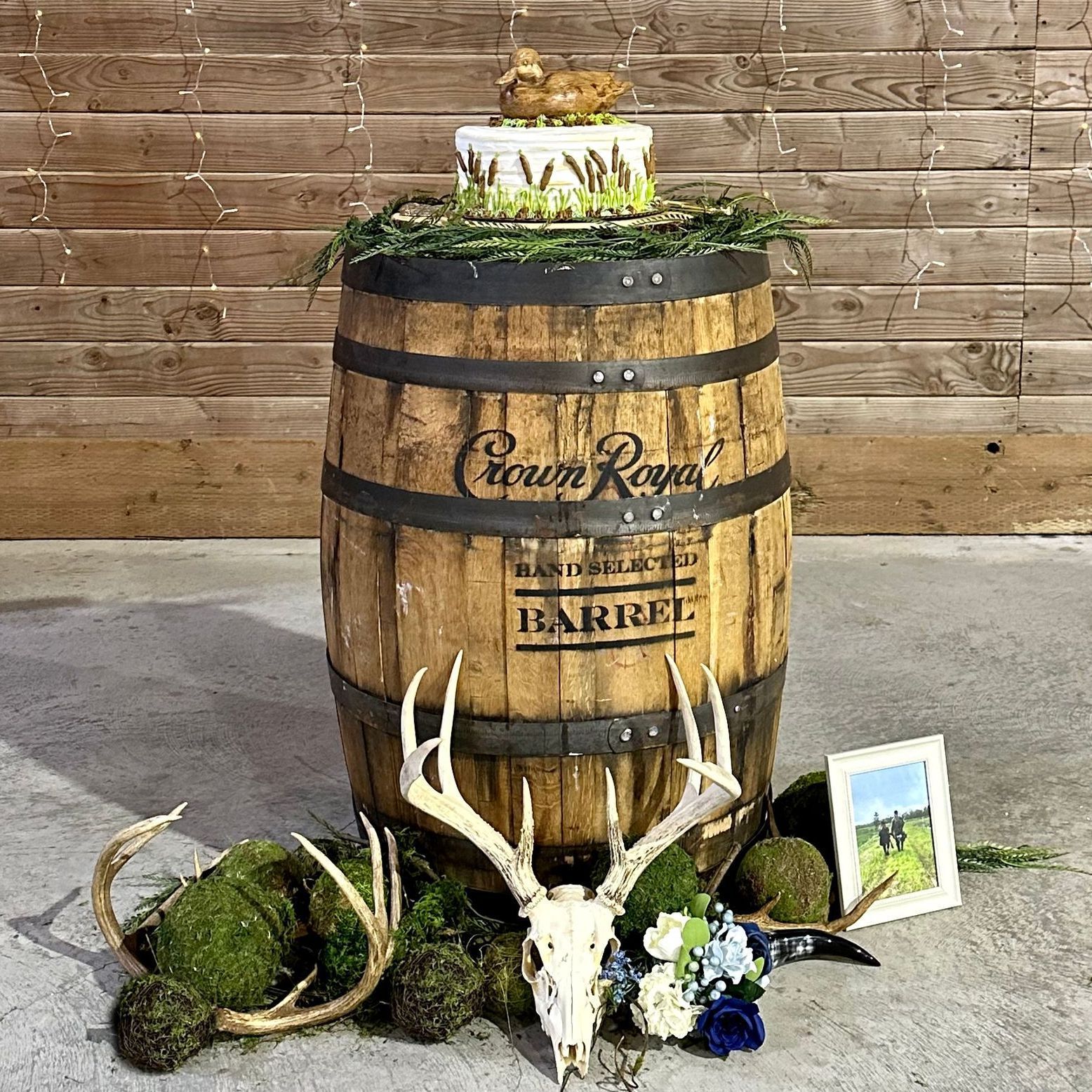 A wooden barrel with a cake on top of it and a deer skull.
