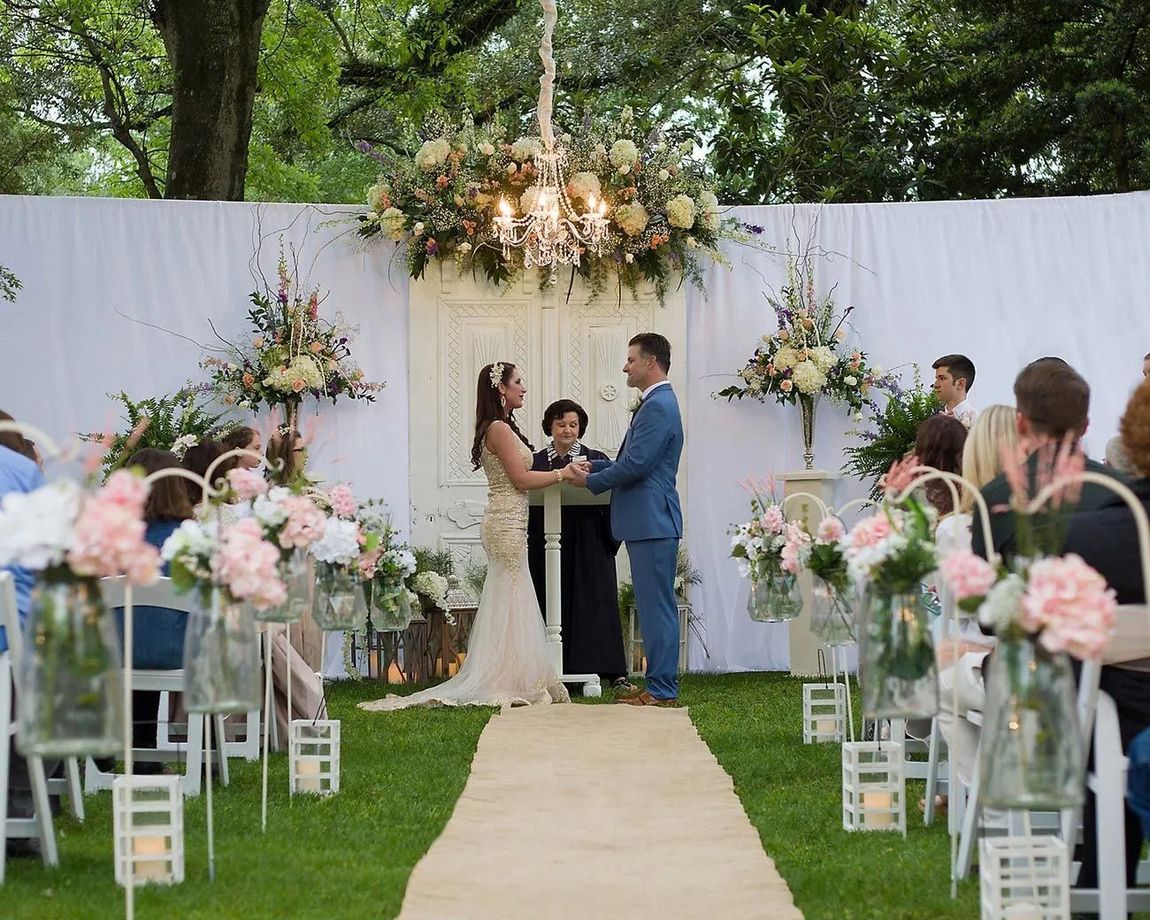 A bride and groom are holding hands during their wedding ceremony.