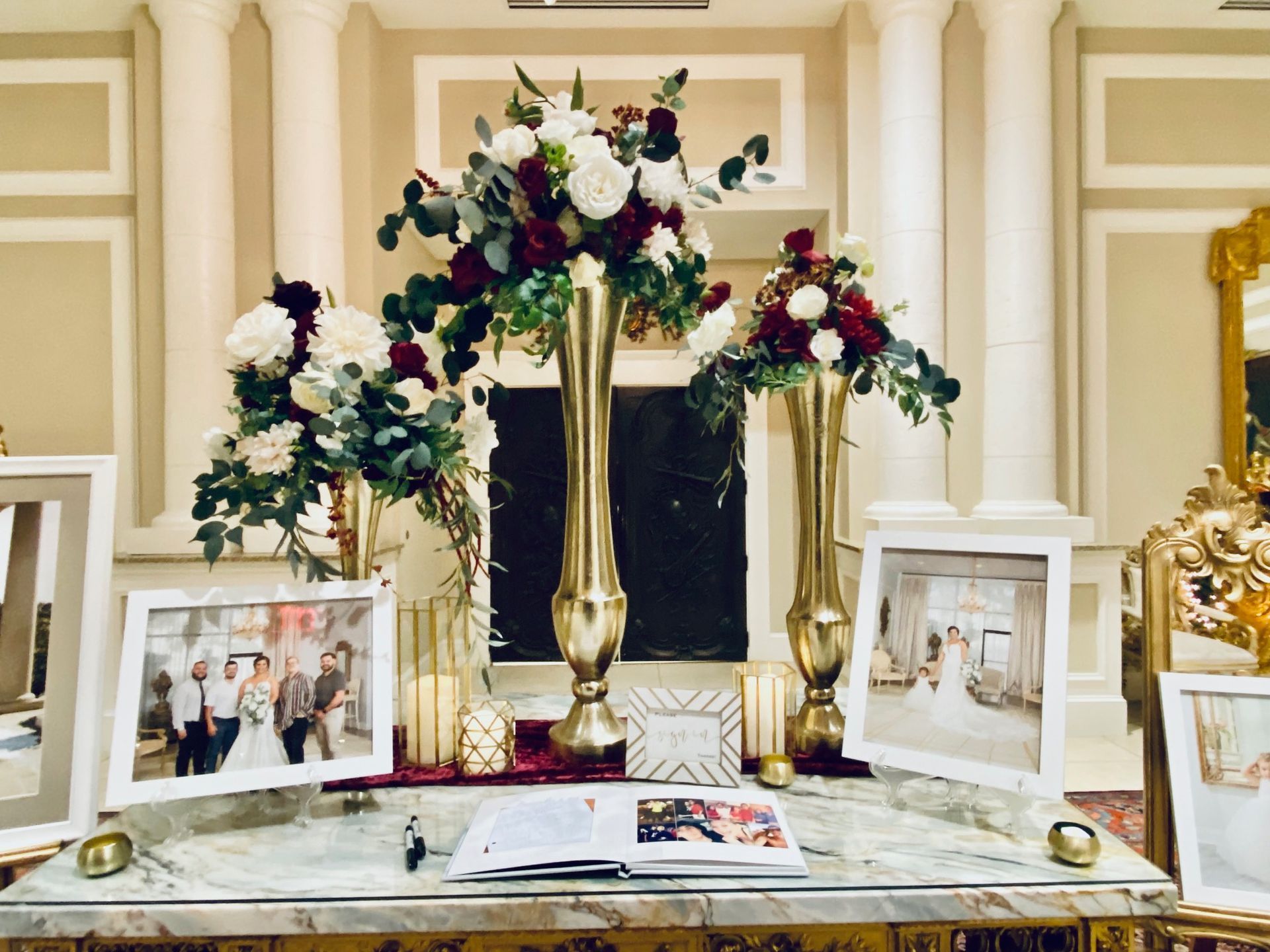 A table with vases of flowers and pictures on it