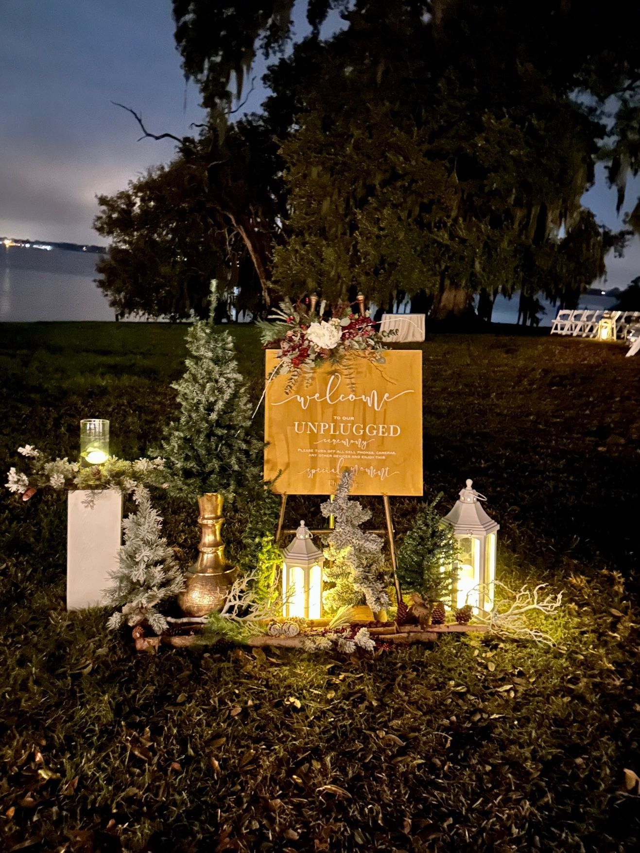 A wooden sign is sitting in the middle of a field at night.