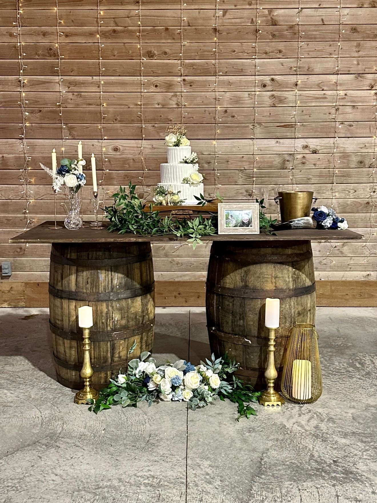 Two wooden barrels are sitting next to each other in front of a wooden wall.