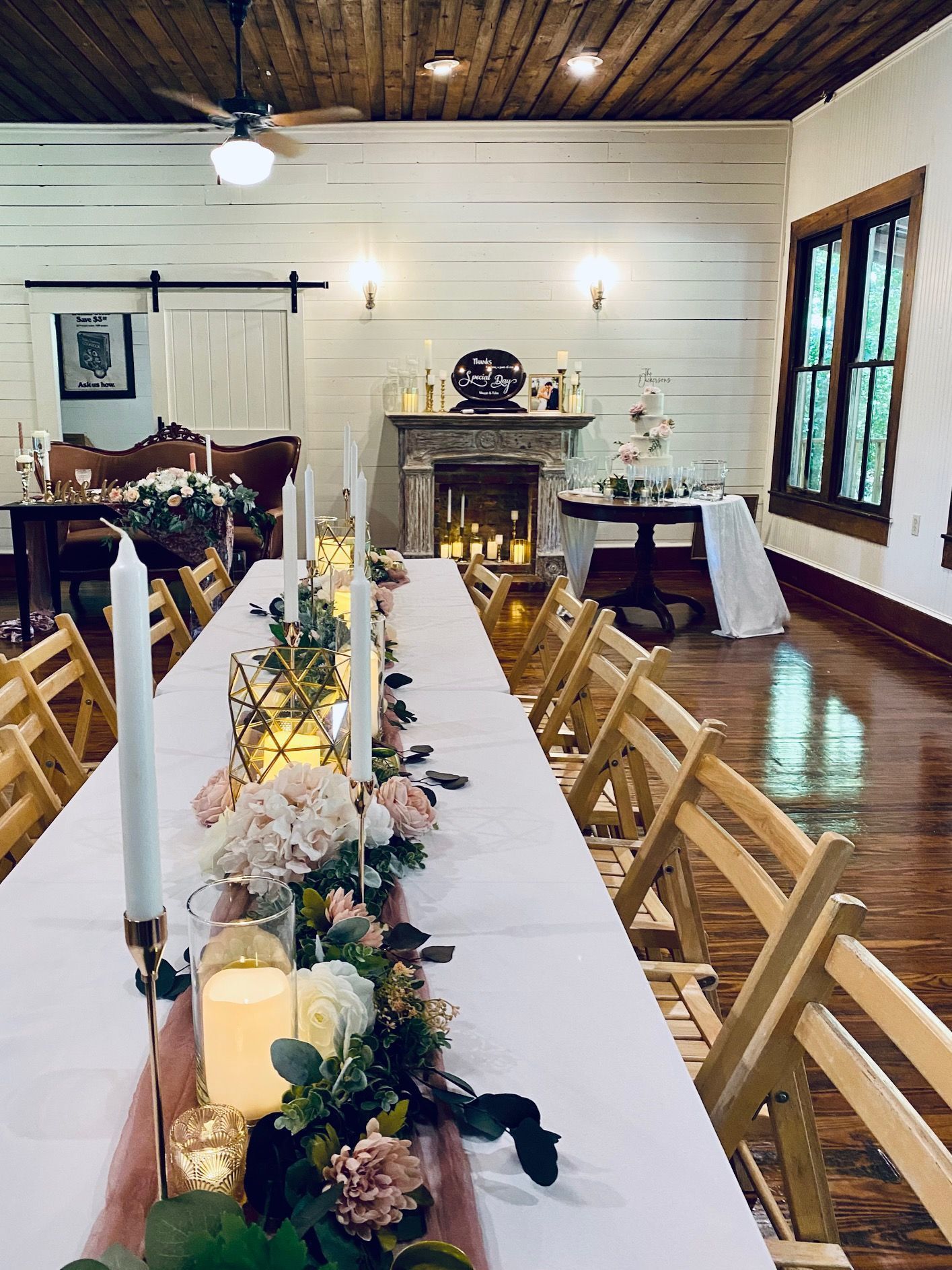 A long table with candles and flowers on it in a room.