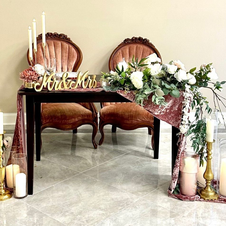 A couple of chairs sitting at a table with flowers and candles.