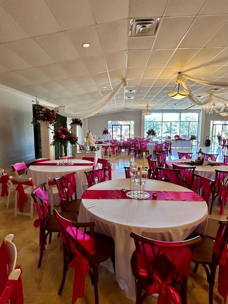 A large room with tables and chairs set up for a wedding reception.