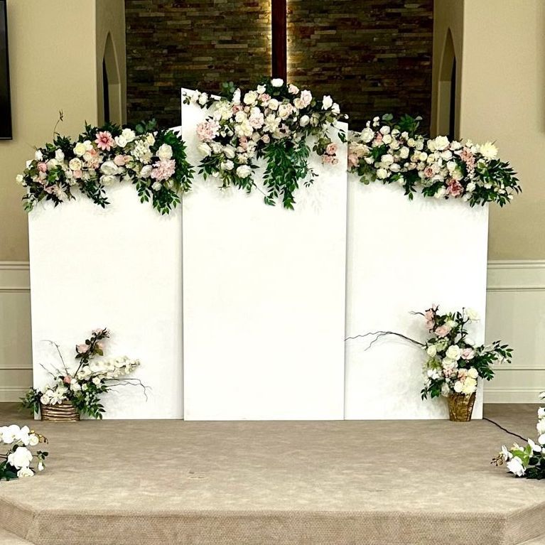A church altar decorated with flowers and a cross.