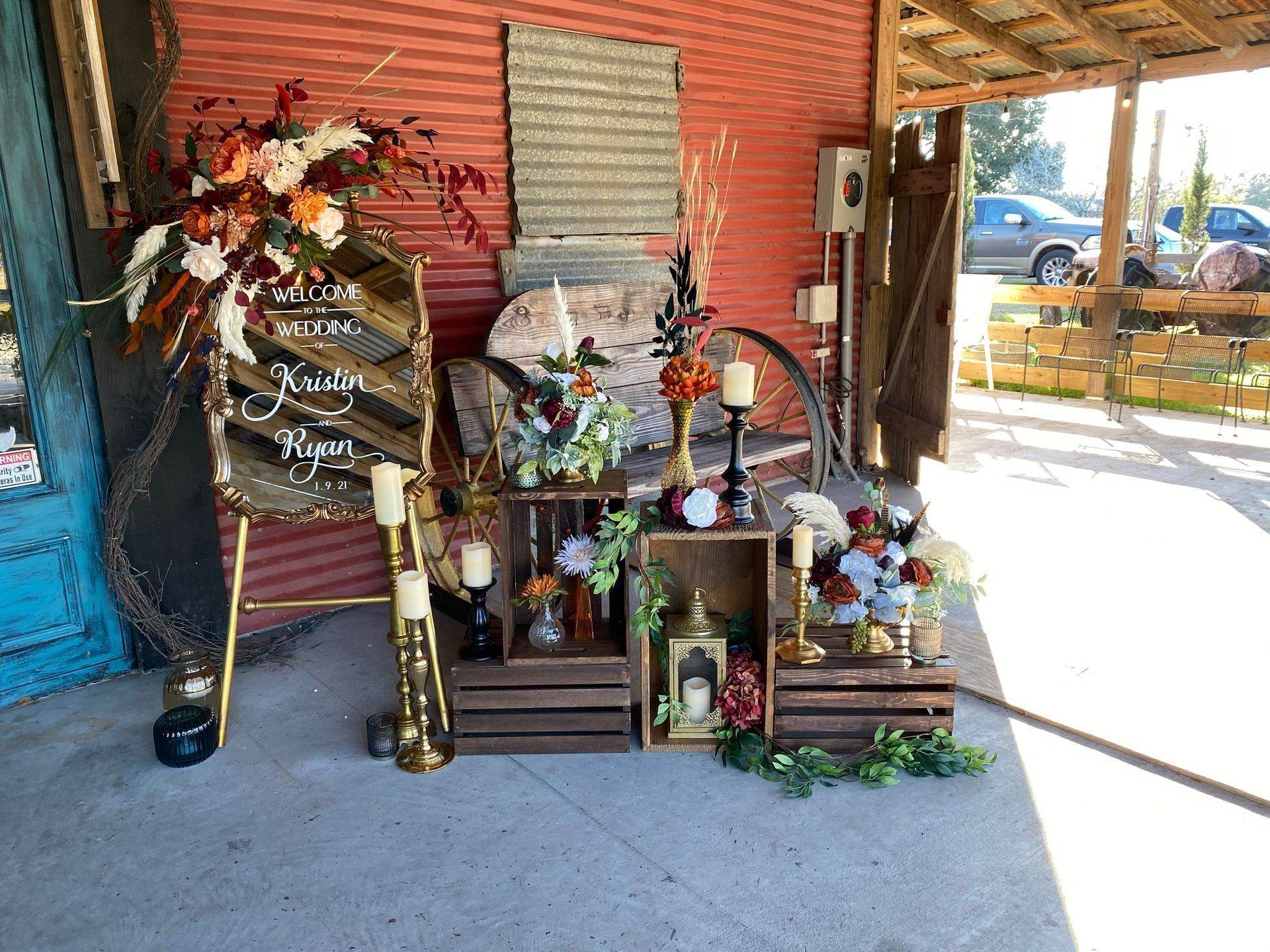 A display of flowers and candles in front of a red wall.