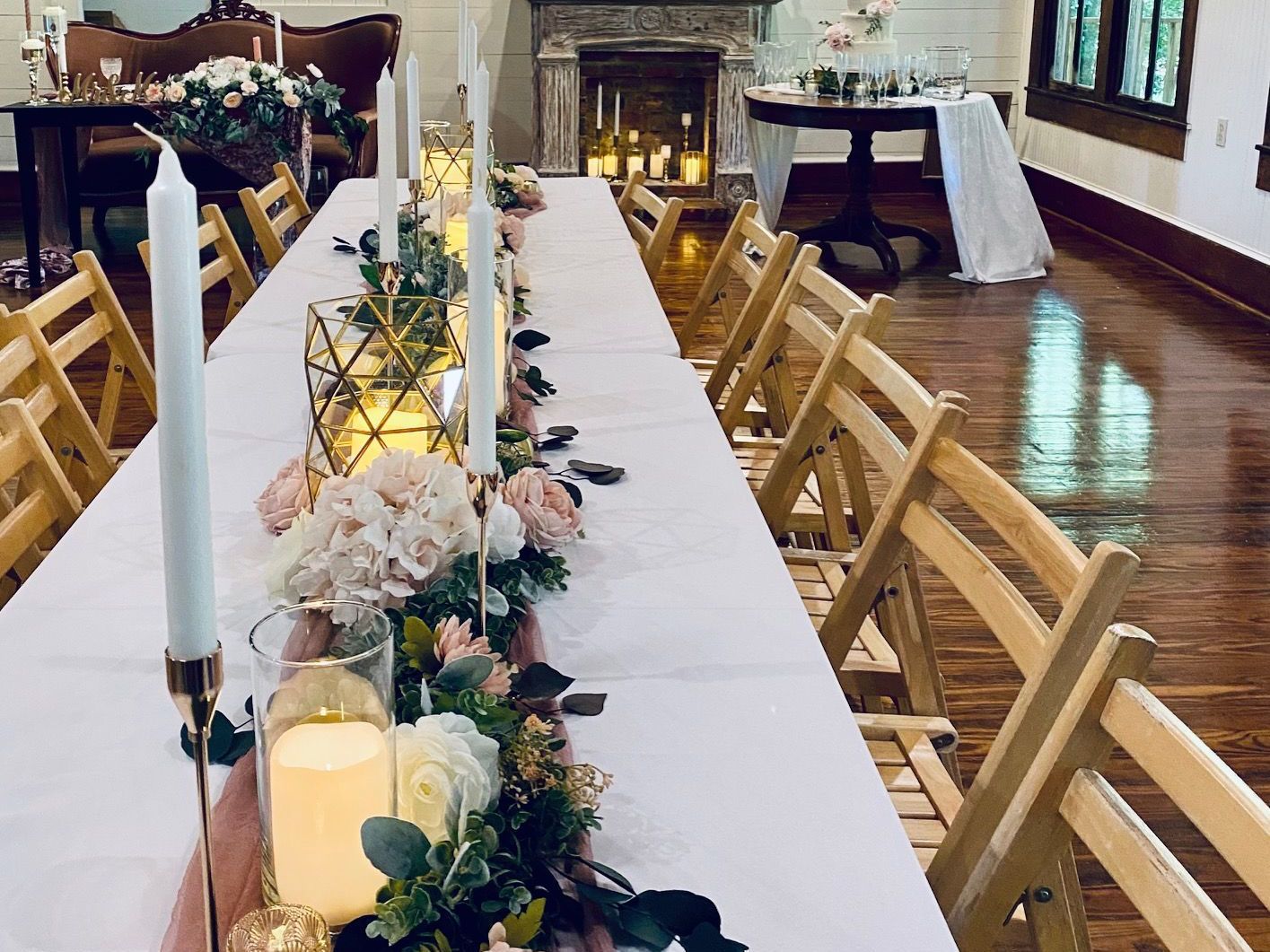 A long table with candles and flowers on it in a room.