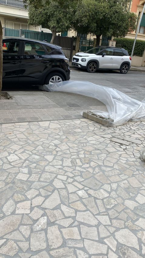 Lastre di pietra grigia posate in modo sovrapposto su un vialetto o un patio