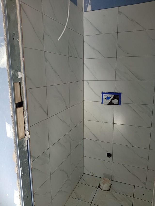 Moquette o rivestimento del pavimento danneggiati e strappati vicino a una porta in un corridoio bianco