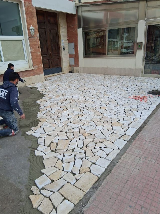 Casa moderna con terrazza in pietra e piscina turchese con vista sul mare.