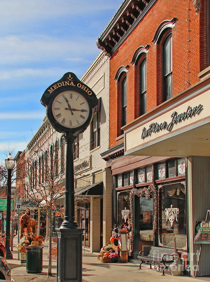 Street view in Medina, Ohio with a clock, brick buildings, and shops.