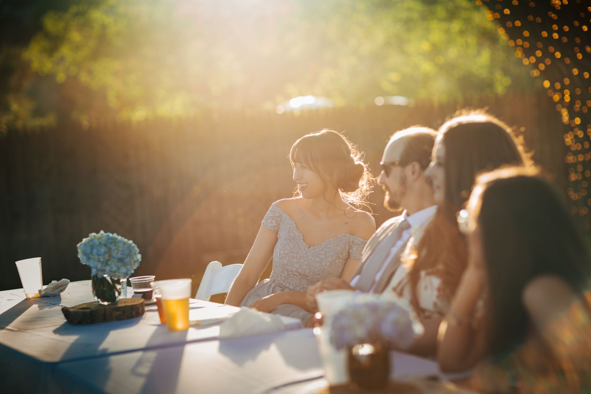 A group of people are sitting at a table at a wedding reception.