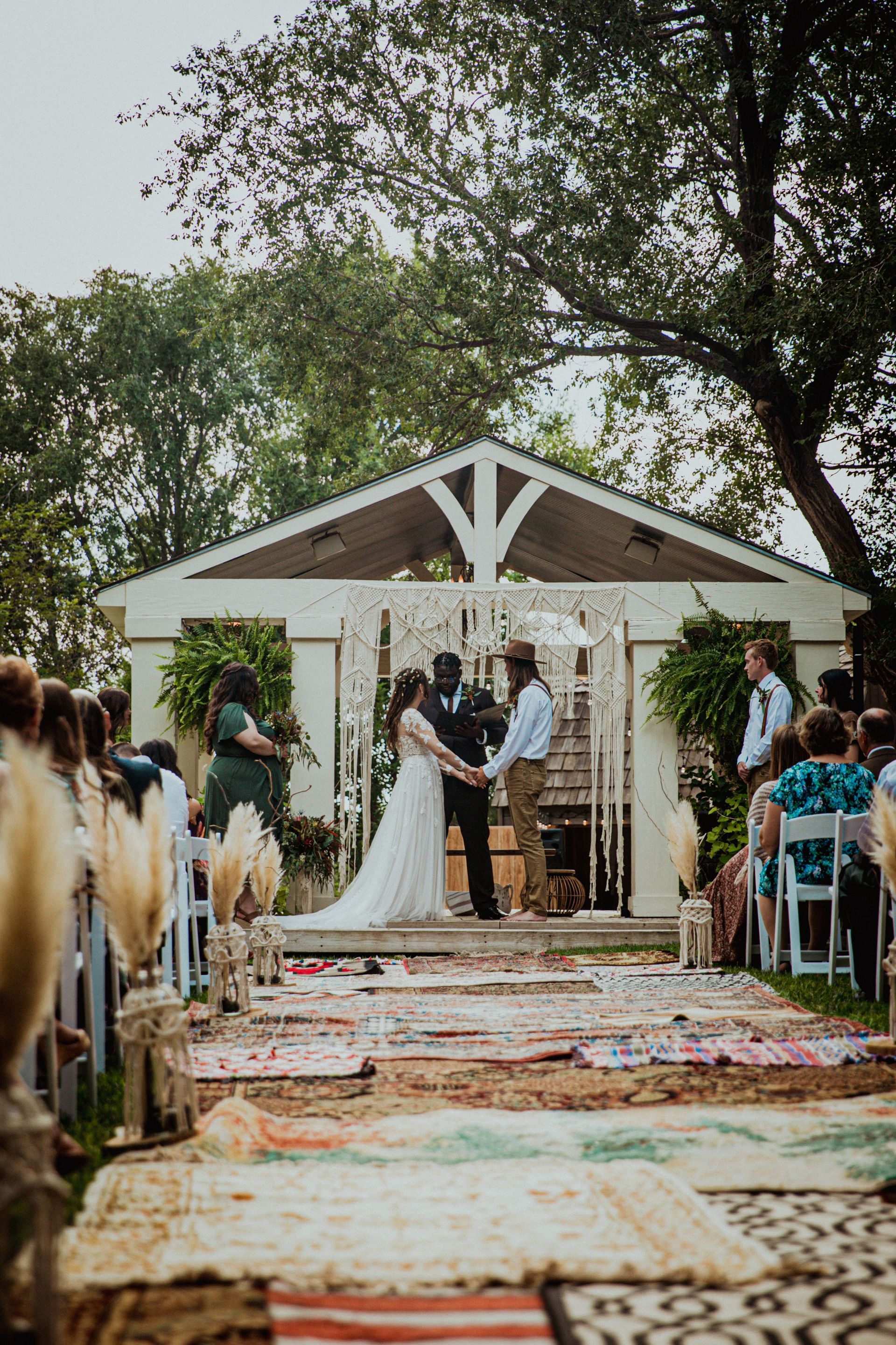 A bride and groom are holding hands during their wedding ceremony.