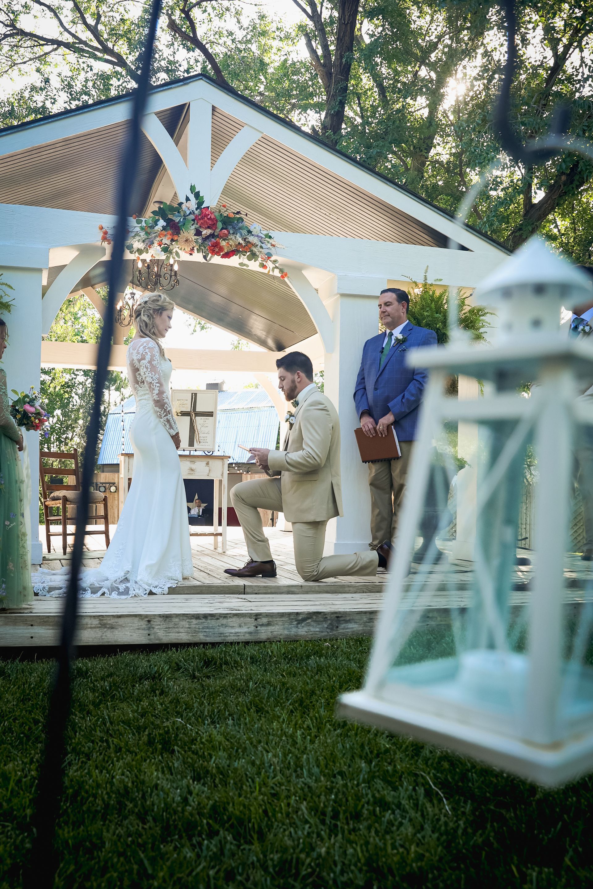 A bride and groom are getting married under a gazebo.