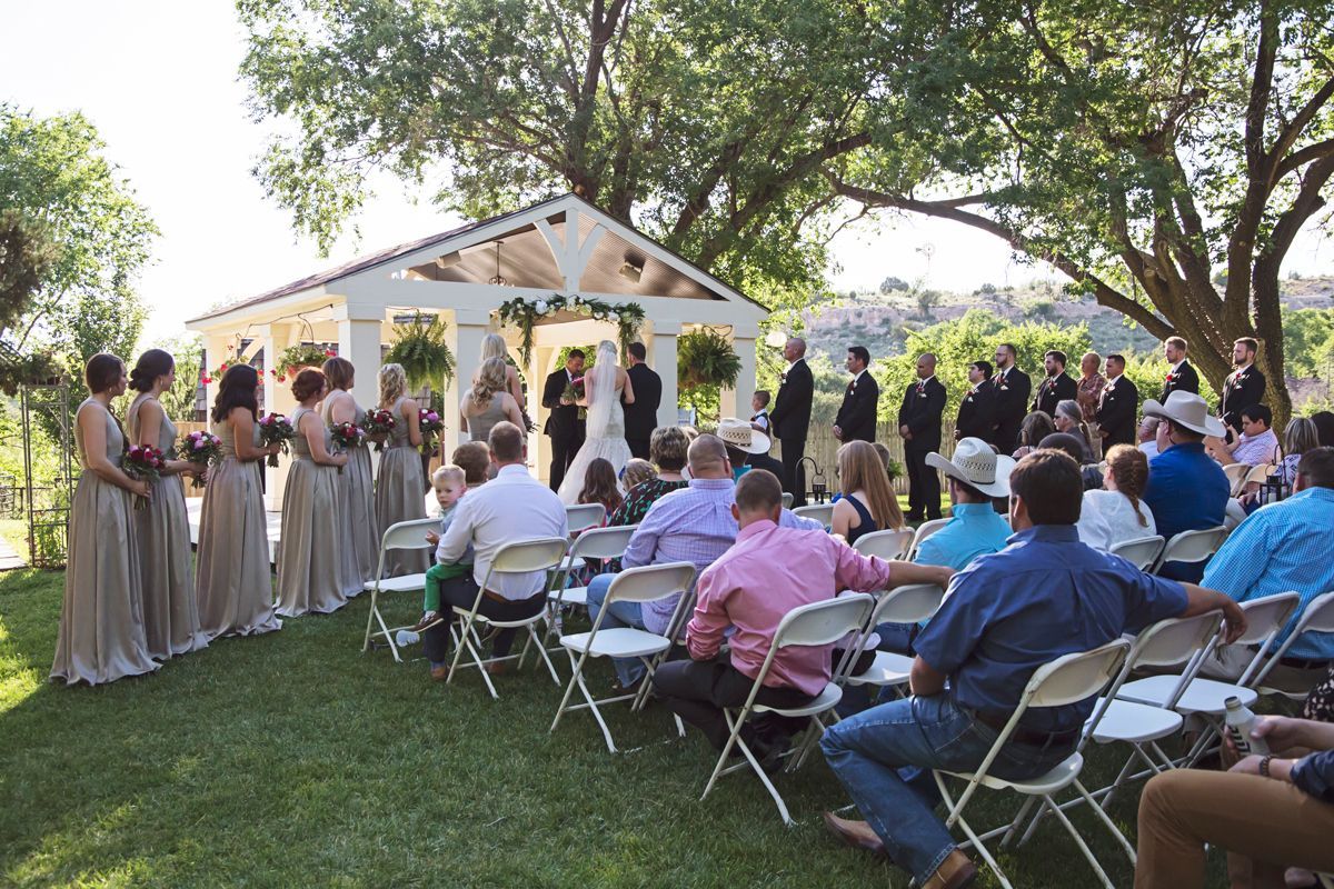 A group of people are sitting in folding chairs at a wedding ceremony.