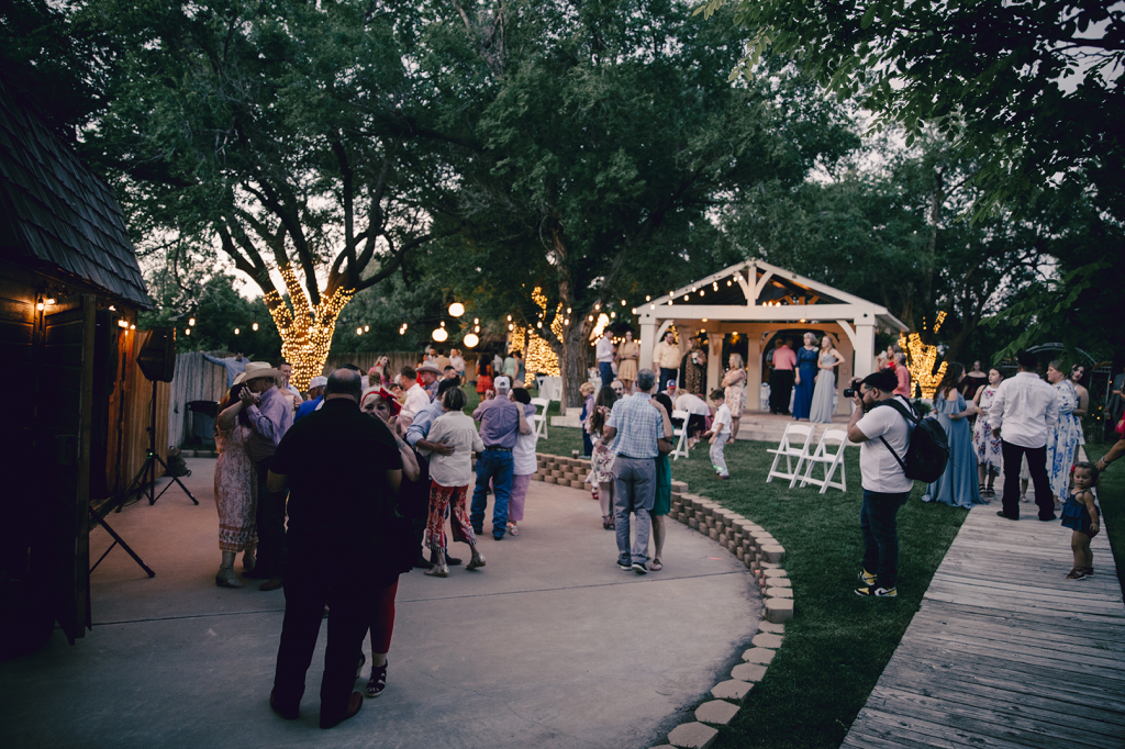 A group of people are standing in front of a stage at a wedding reception.