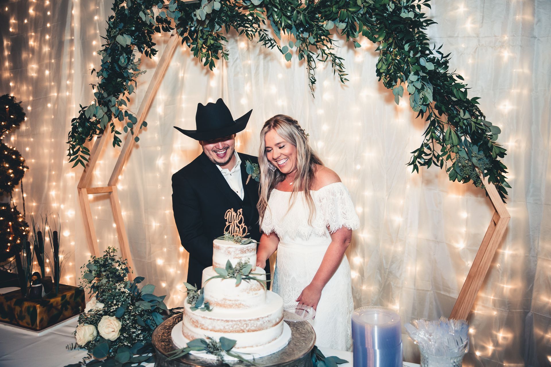 A bride and groom are cutting their wedding cake.