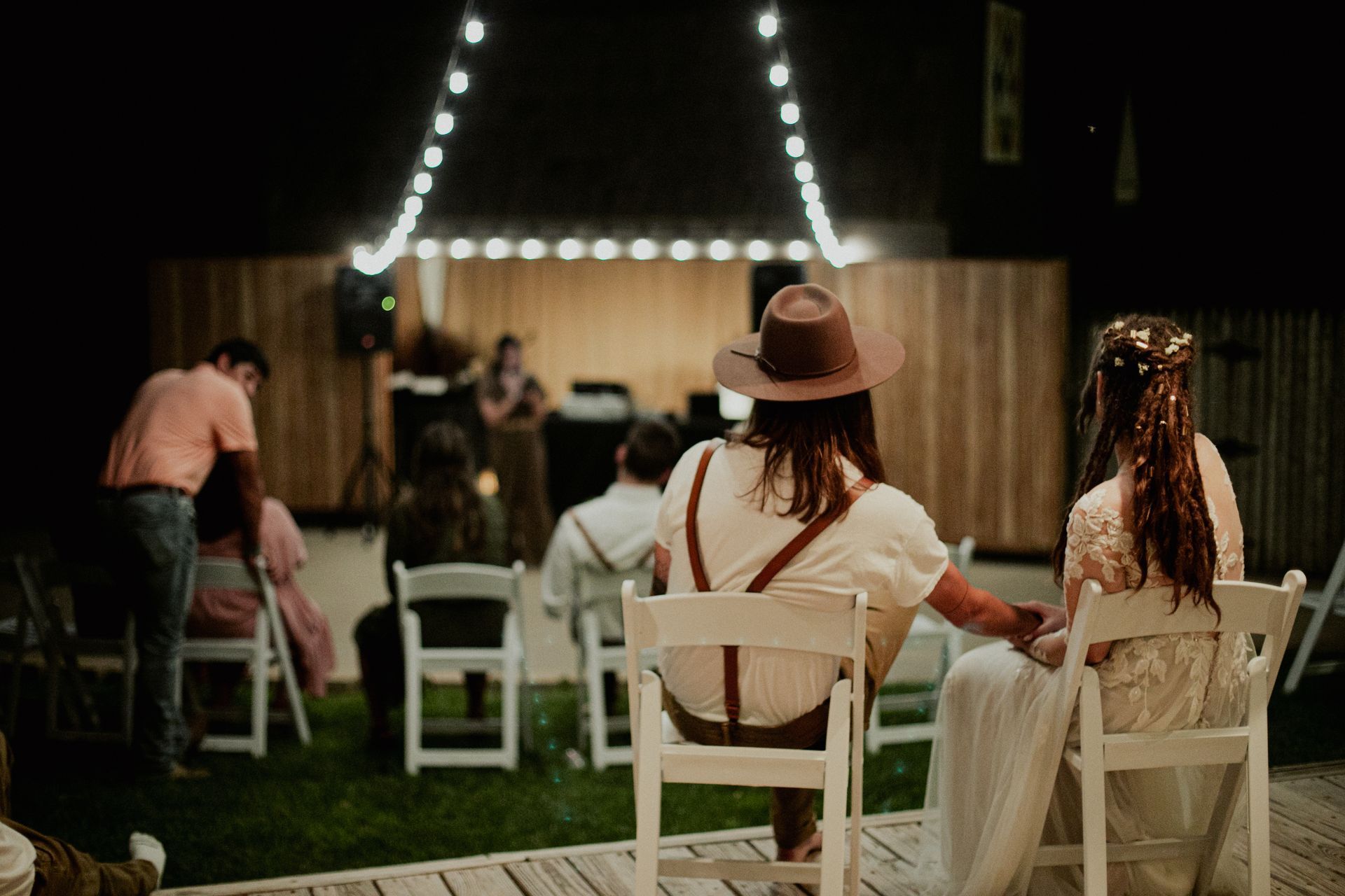 A group of people are sitting in chairs watching a wedding ceremony.