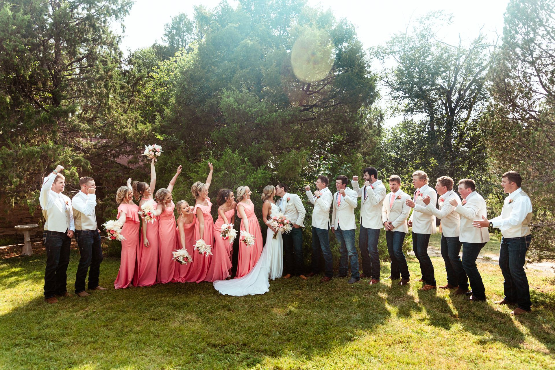 A bride and groom are posing for a picture with their wedding party.