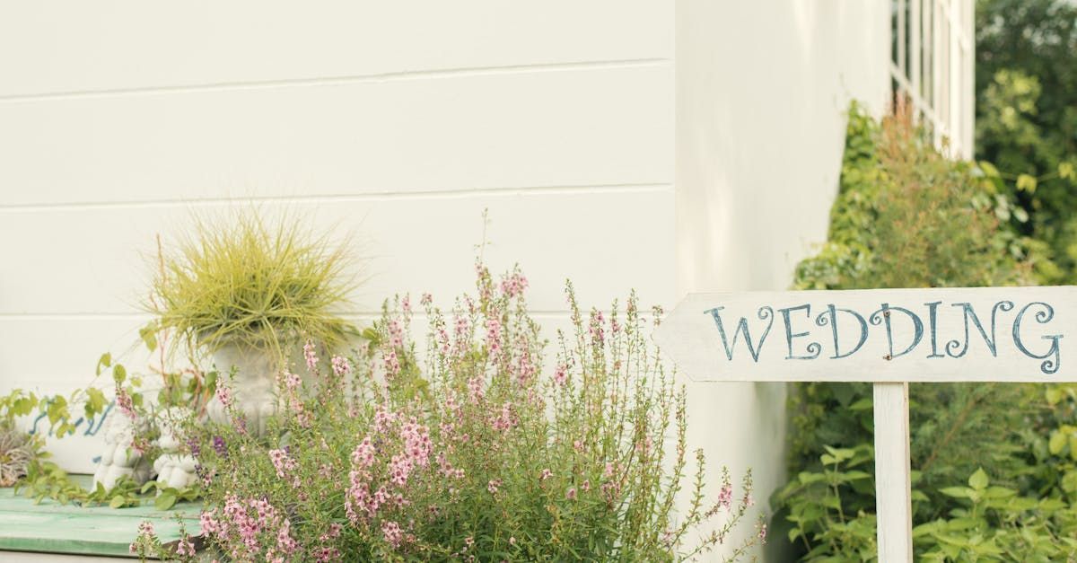 A wedding sign is sitting in front of a white building.