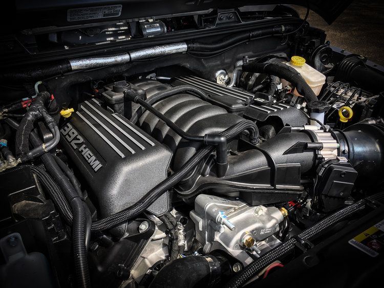 A close up of a car engine with the hood open.