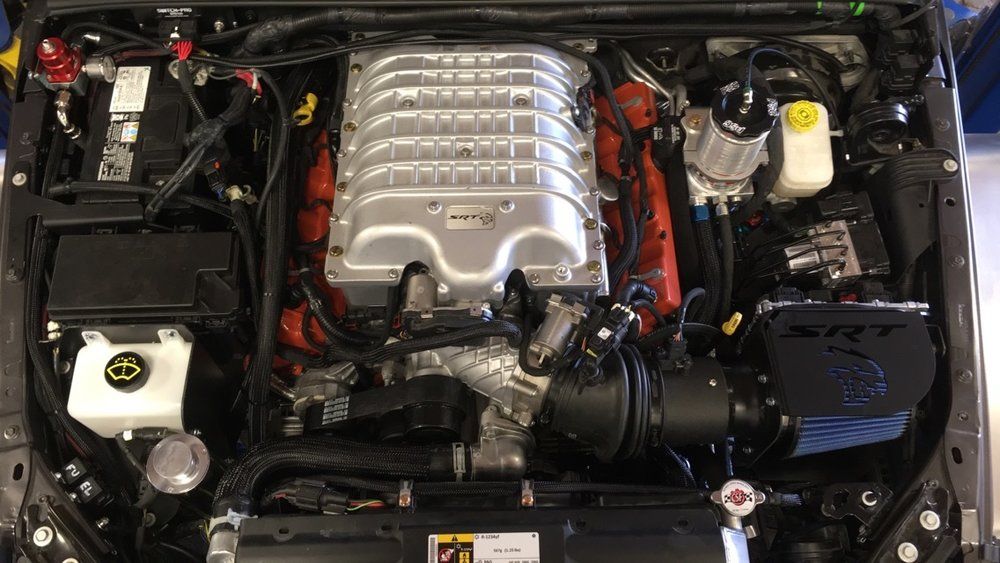 A close up of a car engine with the hood open