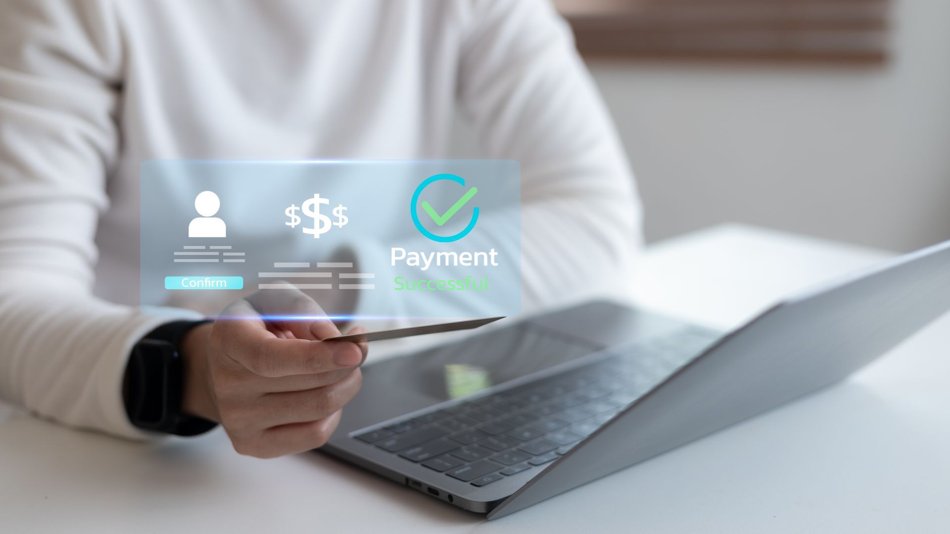 Person using a credit card for online payment on a laptop, with a holographic payment confirmation.