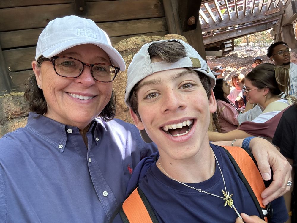 A woman and a boy are posing for a picture together.