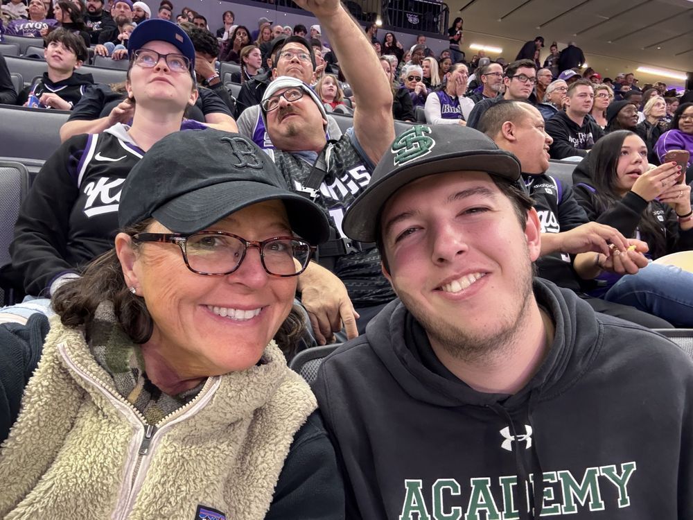 A group of people are sitting in a stadium watching a game.