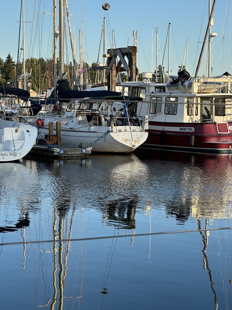 A row of boats are docked in a harbor.