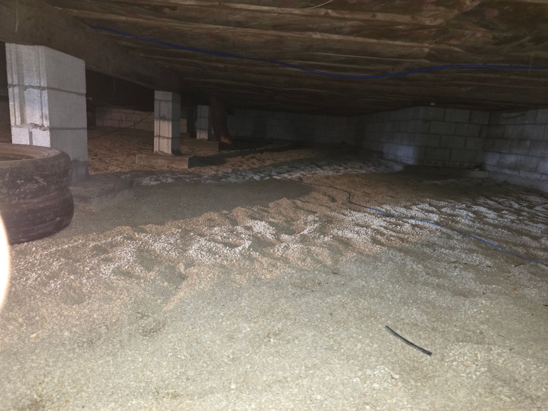 A person is standing in the crawl space of a house.