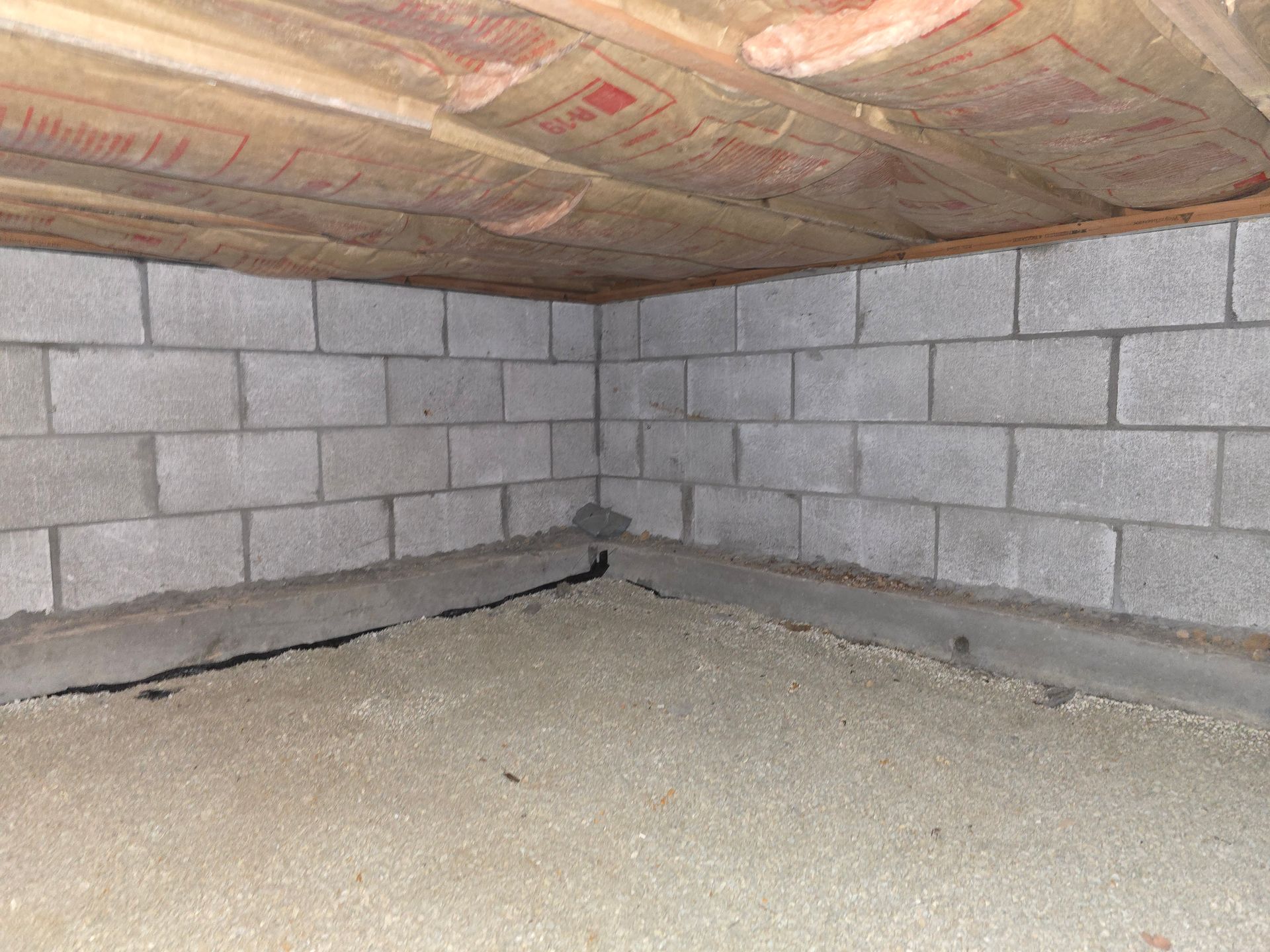 A basement with brick walls and a wooden ceiling.