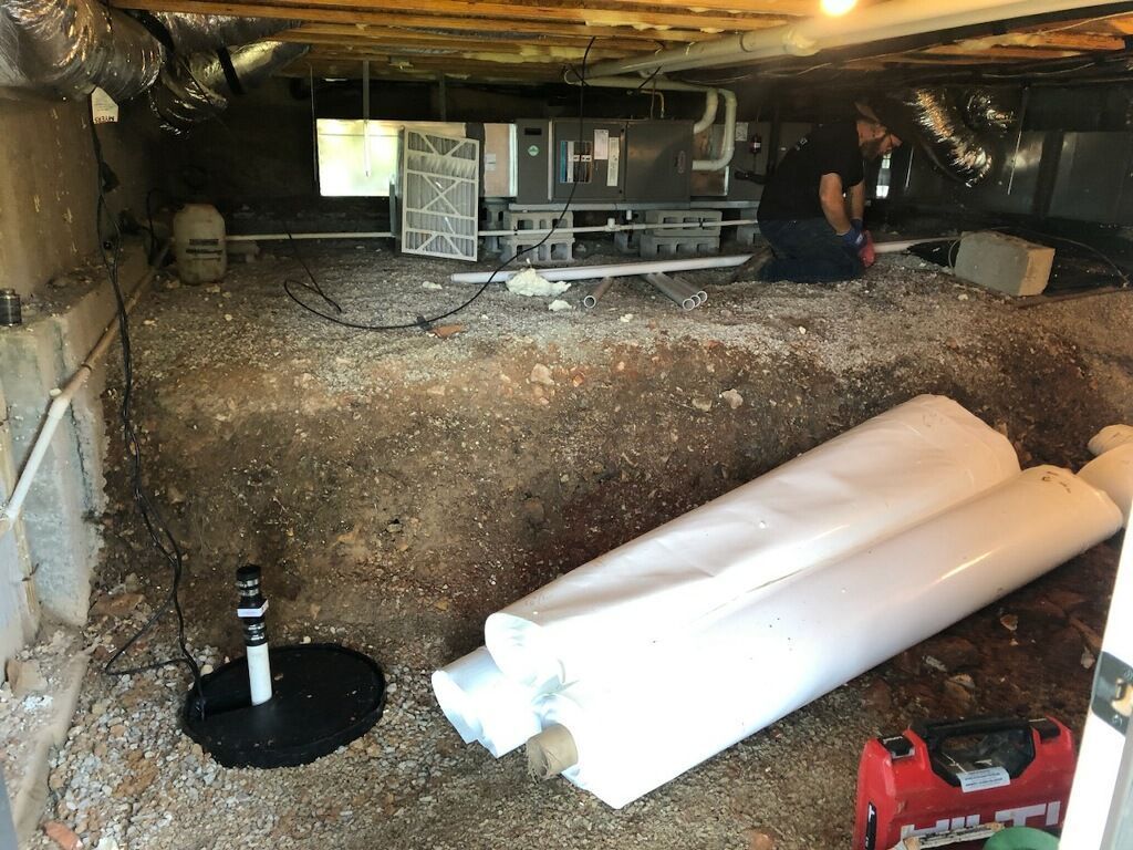 A man is standing in a hole in the ground in a basement.