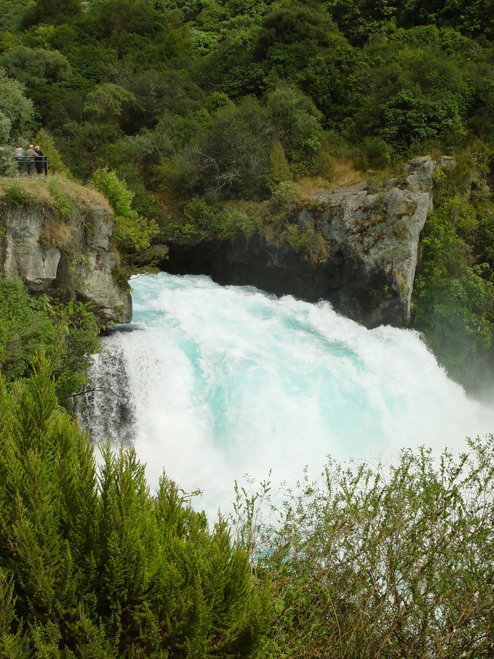A large waterfall is surrounded by trees and rocks