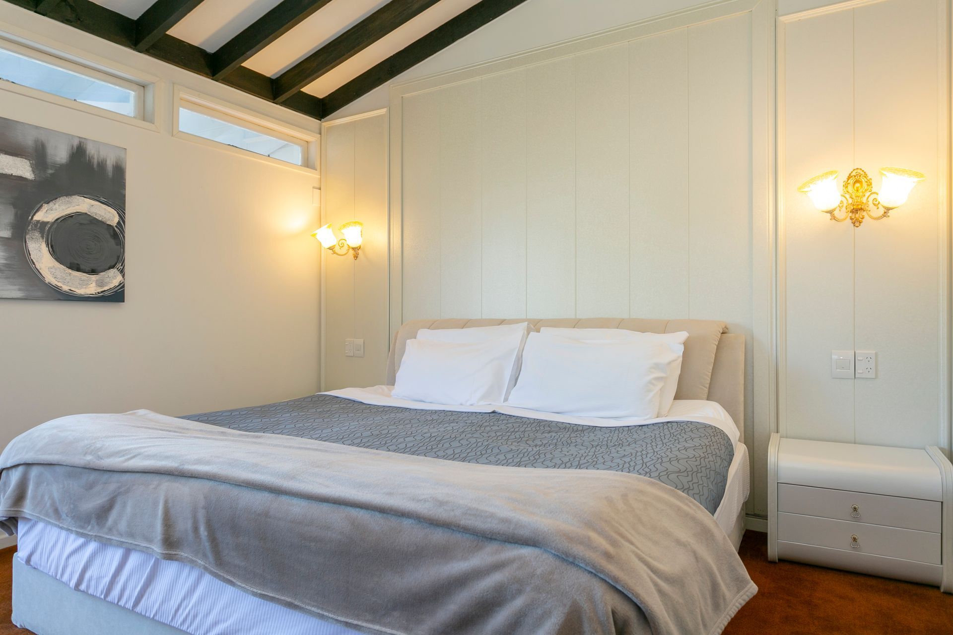 A bedroom with a bed and a painting on the wall