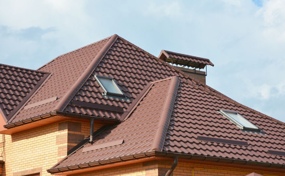 A Person is Using a Drill on a Red Roof — Bradshaw Plumbing & Roofing Pty Ltd In Marian, QLD A Person is Using a Drill on a Red Roof — Bradshaw Plumbing & Roofing Pty Ltd In Marian, QLD
