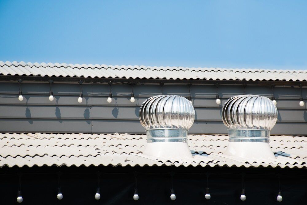 Two Wind Turbines Are on the Roof of a Building — Bradshaw Plumbing & Roofing Pty Ltd In East Mackay, QLD