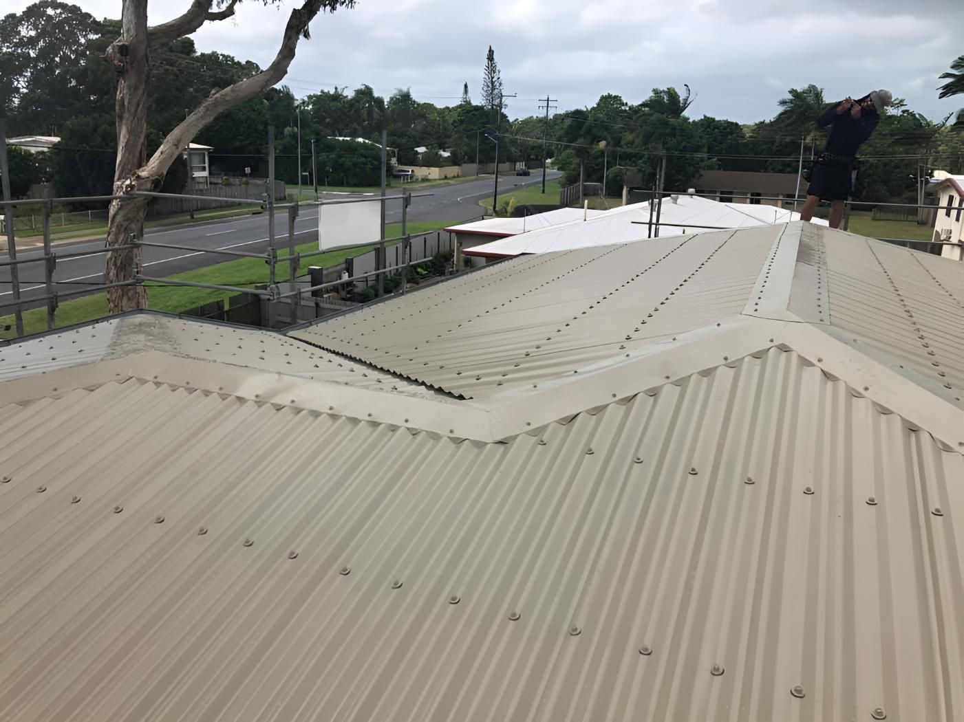 A Roof With a Tree in the Background and a Road in the Background — Bradshaw Plumbing & Roofing Pty Ltd In East Mackay, QLD