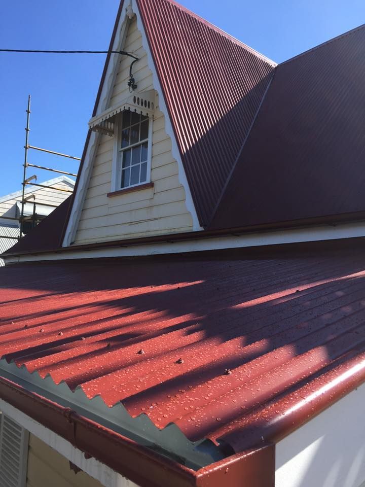 A House With a Red Roof and a Window — Bradshaw Plumbing & Roofing Pty Ltd In East Mackay, QLD A House With a Red Roof and a Window — Bradshaw Plumbing & Roofing Pty Ltd In East Mackay, QLD