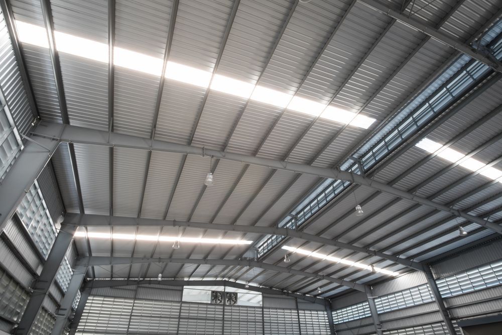 The Inside of a Large Warehouse With a Metal Roof — Bradshaw Plumbing & Roofing Pty Ltd In Ooralea, QLD The Inside of a Large Warehouse With a Metal Roof — Bradshaw Plumbing & Roofing Pty Ltd In Ooralea, QLD